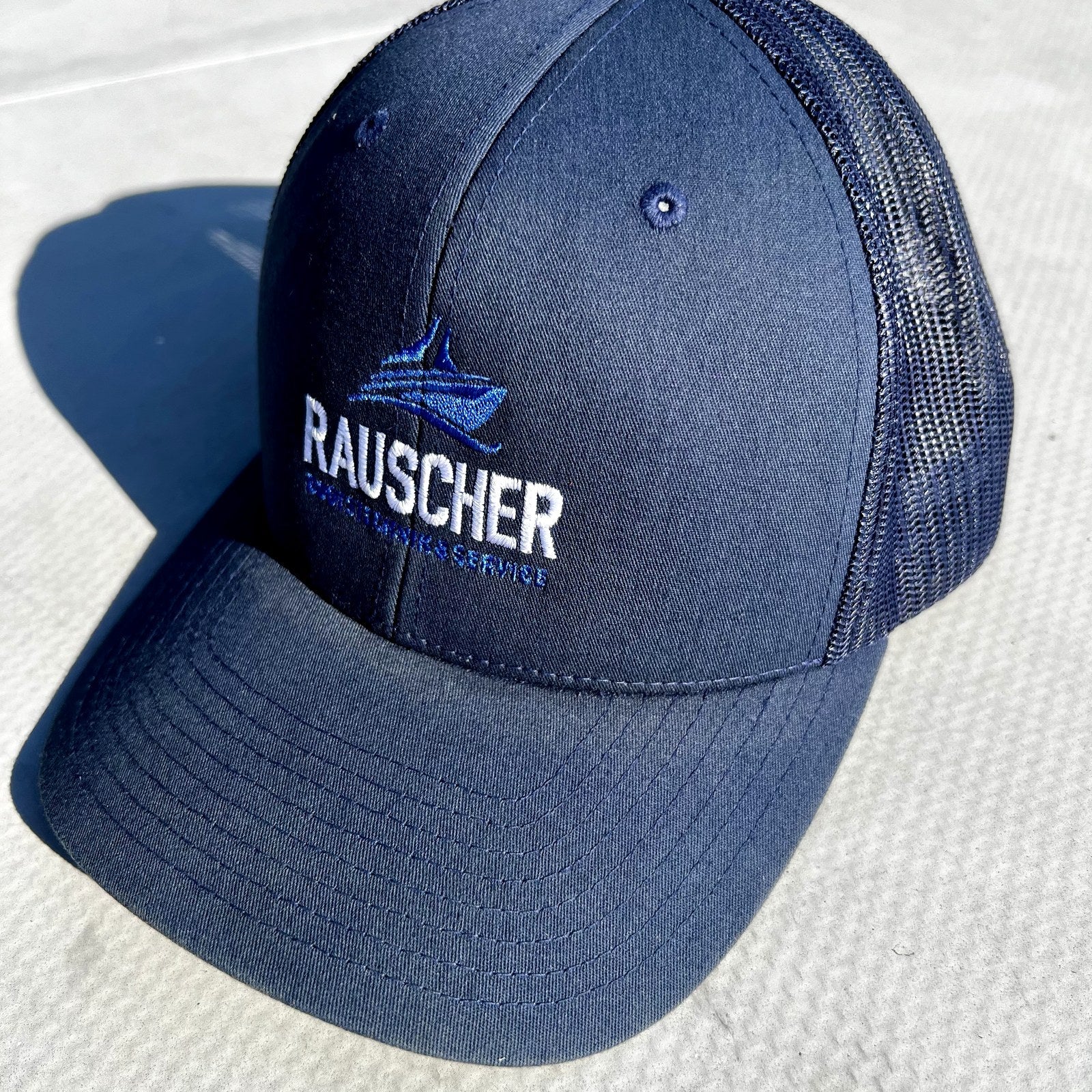 Rauscher Boot Trucker Cap in Marineblau, Dreiviertelansicht mit gesticktem Logo